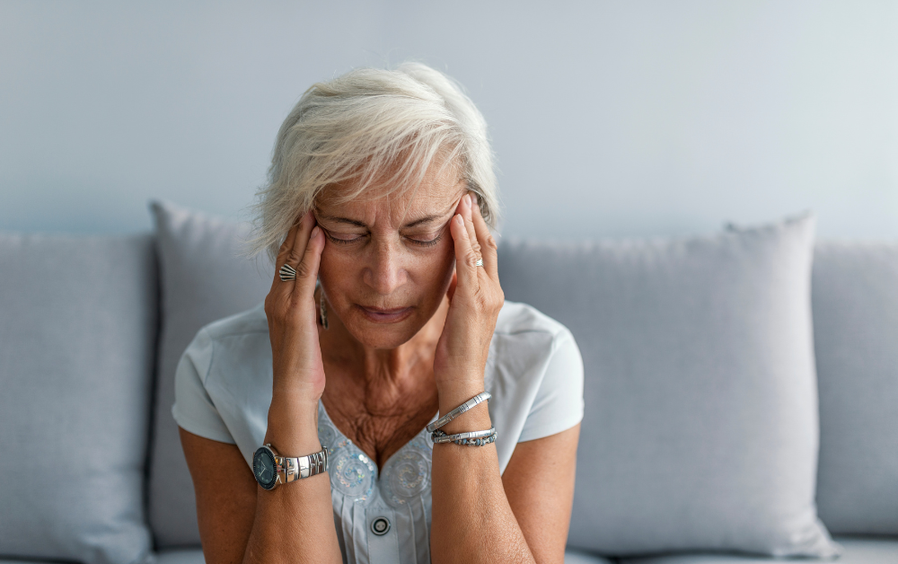 woman holding her temples because of a migraine & headache