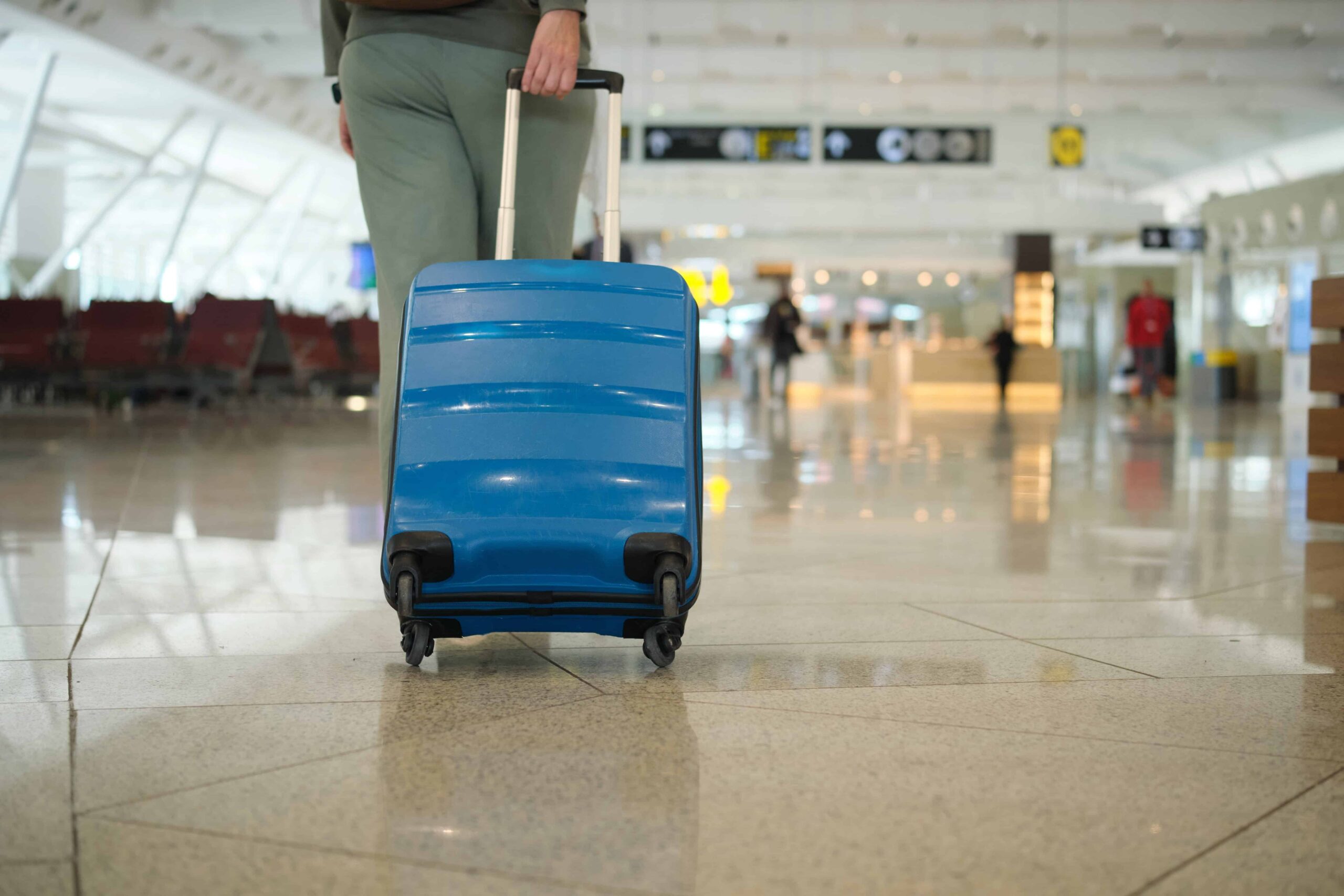 traveling internationally - woman in airport with suitcase